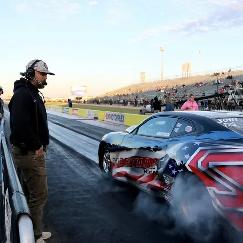A crew member watches the COPO Camaro's burnout from the wall