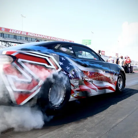 The flag-wrapped COPO Camaro doing a burnout at Indianapolis