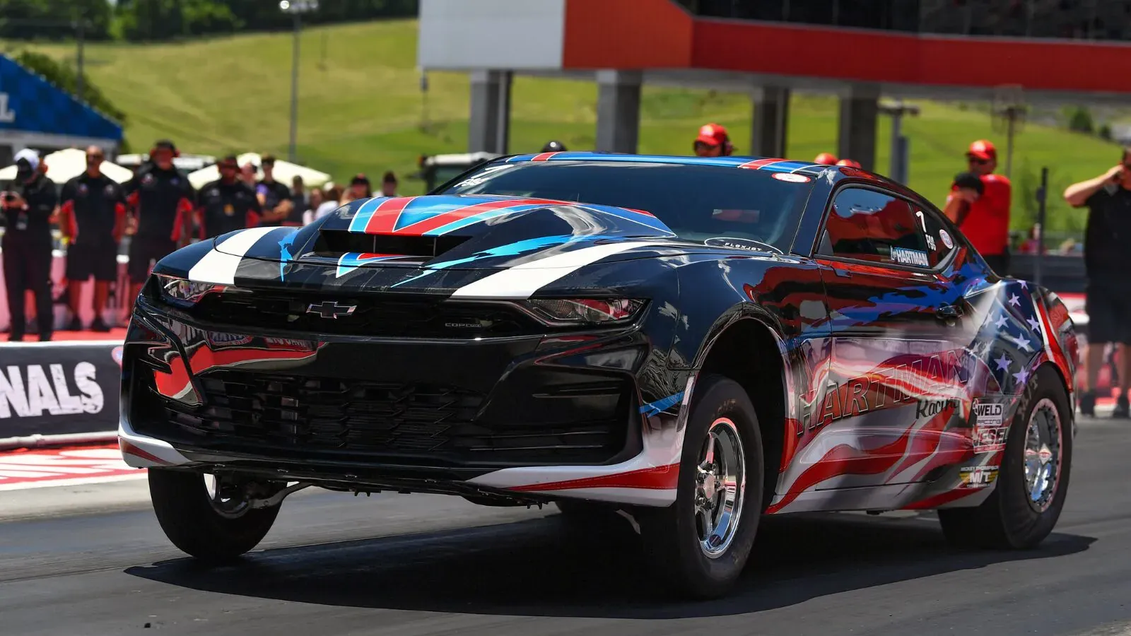 Matthew Hartman's flag-wrapped Hartman Racing COPO Camaro launching off the starting line